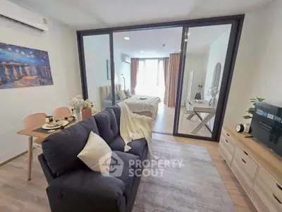 Modern open-plan living room with cozy seating and stylish decor in a bright apartment.