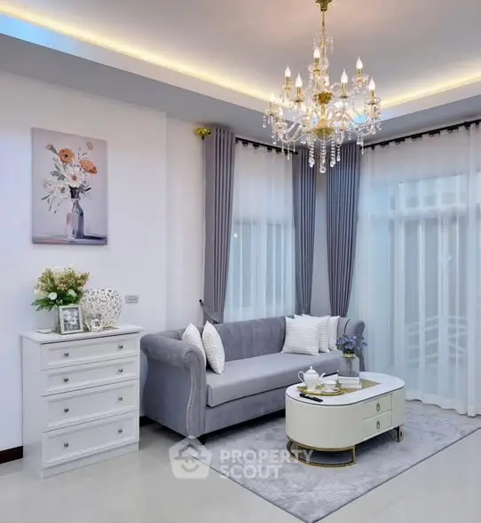 Elegant living room with chandelier, plush sofa, and stylish decor