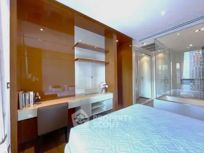Luxurious bedroom with modern built-in desk and glass-walled bathroom, offering a sleek and stylish living space.