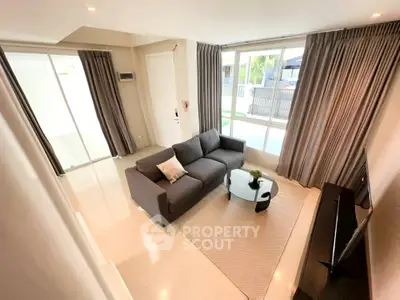Spacious living room with modern decor and large windows for natural light.