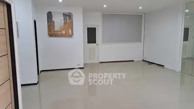 Spacious empty room with glossy tiled flooring and modern wall art.