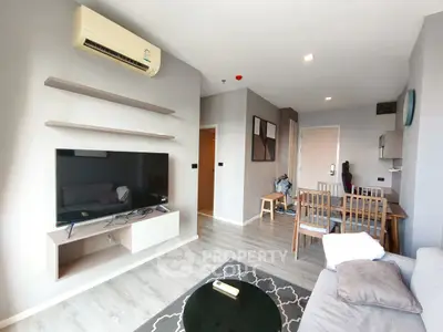 Modern living room with sleek furniture and wall-mounted TV in stylish apartment.