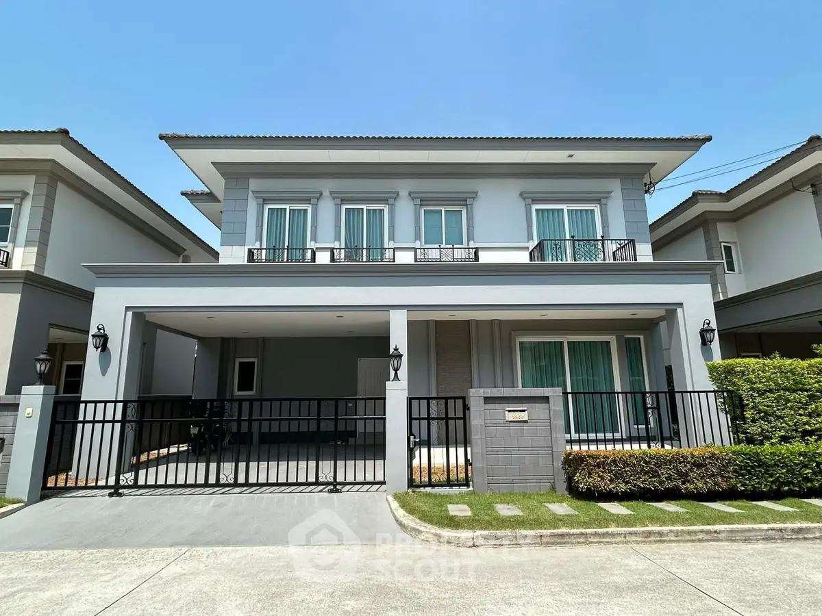 Modern two-story house with spacious driveway and manicured lawn in a serene neighborhood.