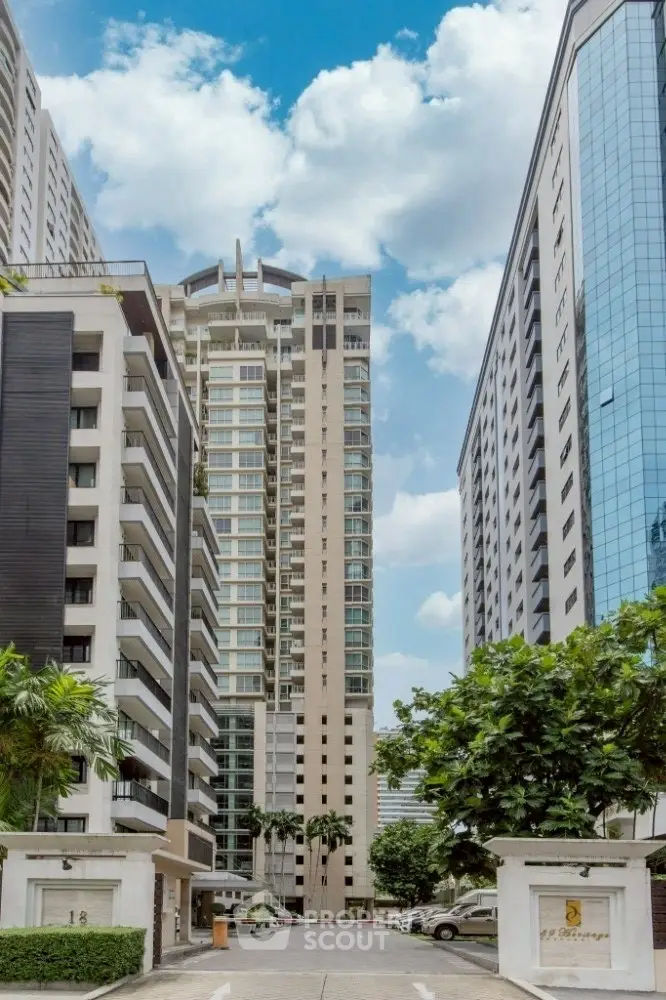 Stunning high-rise residential buildings with lush greenery and clear blue sky.