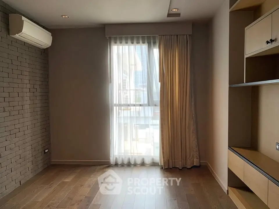 Spacious room with wooden flooring and large window in modern apartment
