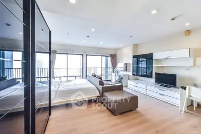 Spacious modern studio apartment with large windows and stylish furnishings