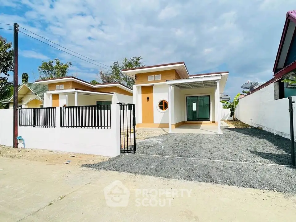 Modern single-story house with unique circular window and spacious driveway