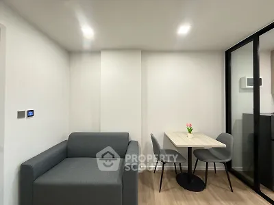 Modern living room with sleek gray sofa and compact dining area, perfect for urban living.