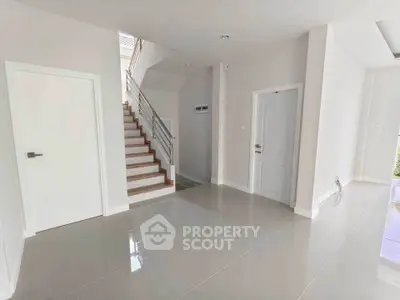Spacious modern interior with sleek staircase and glossy tiled floors.