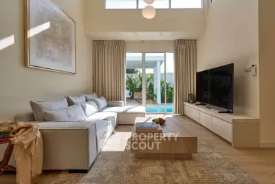 Luxurious living room with pool view, modern decor, and ample natural light.