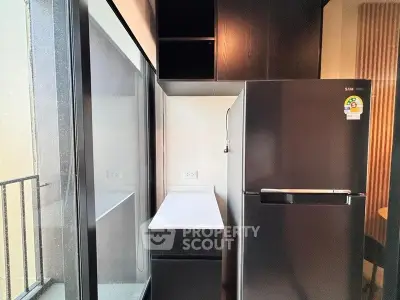 Modern kitchen with sleek black fridge and ample storage space