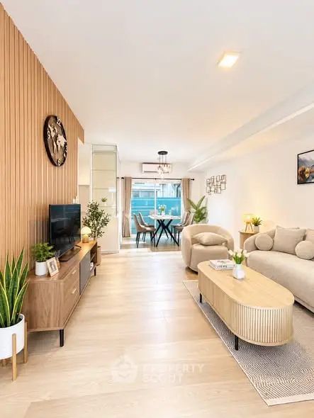 Modern living room with stylish decor and open layout, featuring a cozy seating area and dining space.