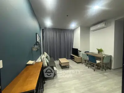 Modern living room with stylish decor and dining area, featuring sleek furniture and ambient lighting.