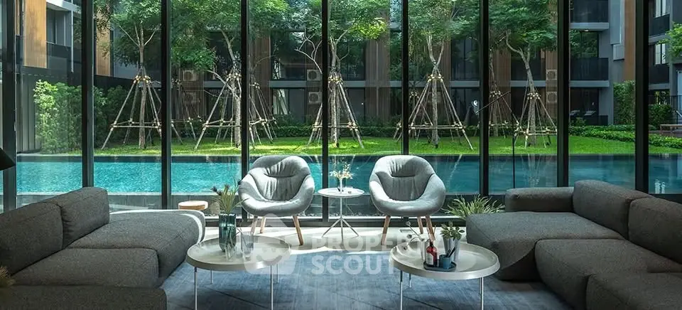 Luxurious living room with floor-to-ceiling windows overlooking a serene pool and garden.