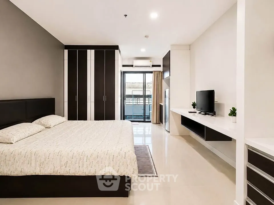 Spacious modern bedroom with sleek design and balcony access