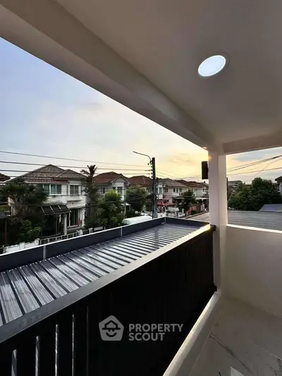 Charming balcony view at sunset overlooking suburban neighborhood with modern homes.