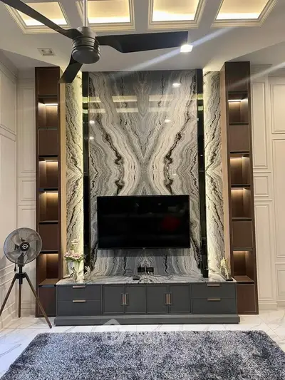 Luxurious living room with marble accent wall and modern entertainment setup
