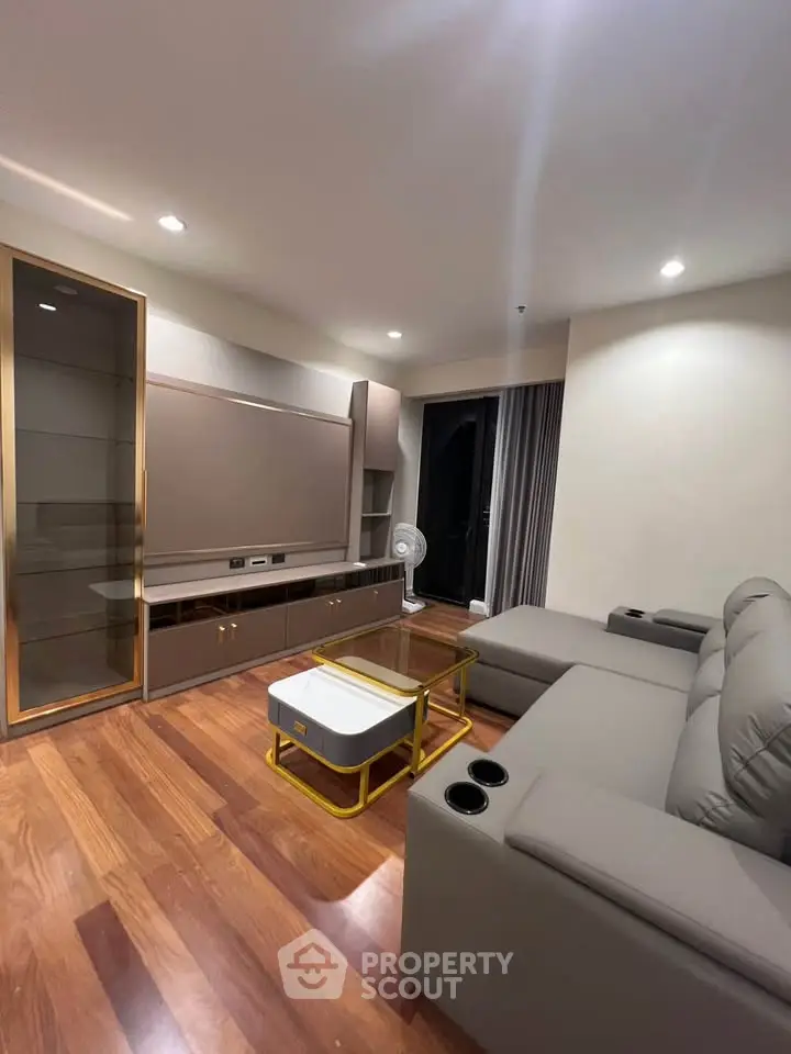 Modern living room with sleek furniture and wooden flooring, perfect for relaxation and entertainment.