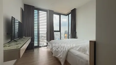Modern bedroom with floor-to-ceiling windows and city view