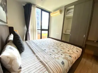 Cozy bedroom with large window and built-in wardrobe in modern apartment