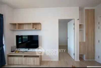Modern living room with minimalist wooden furniture and wall-mounted TV.