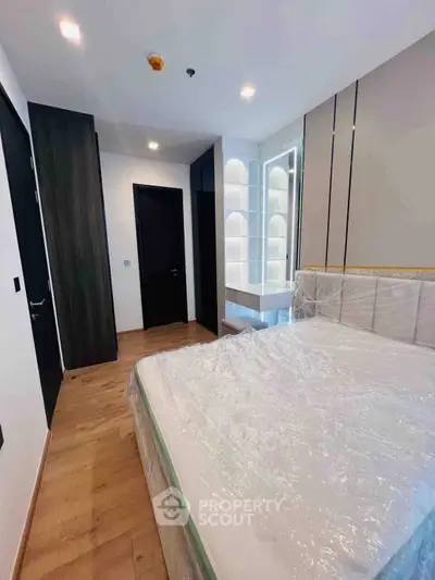 Modern bedroom with sleek design and ample natural light, featuring a stylish bed and built-in storage.