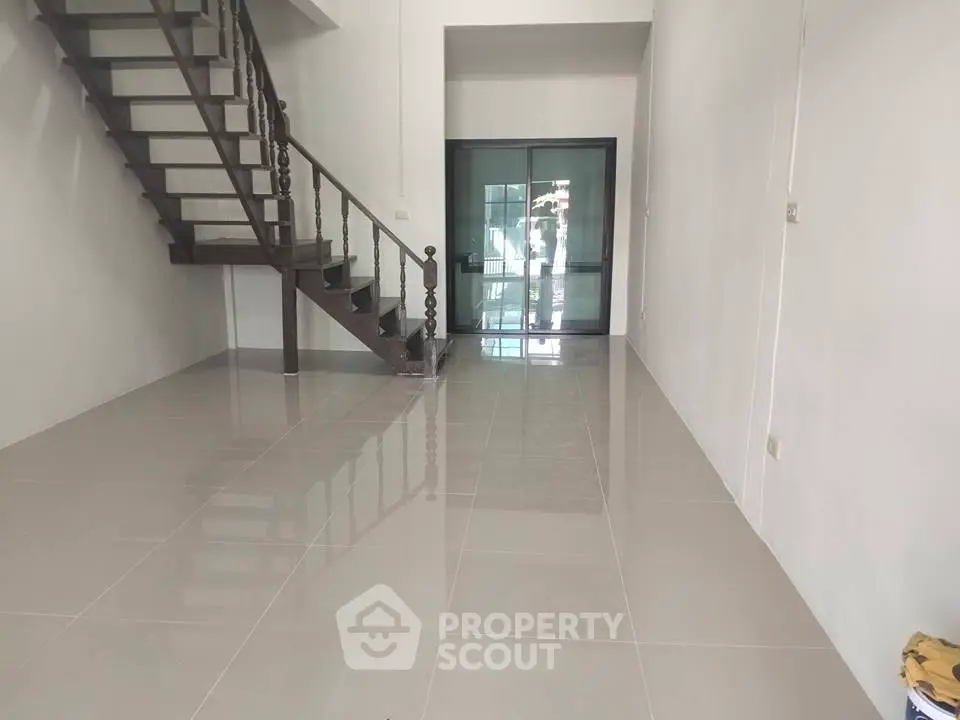 Spacious modern interior with sleek staircase and glossy tiled flooring