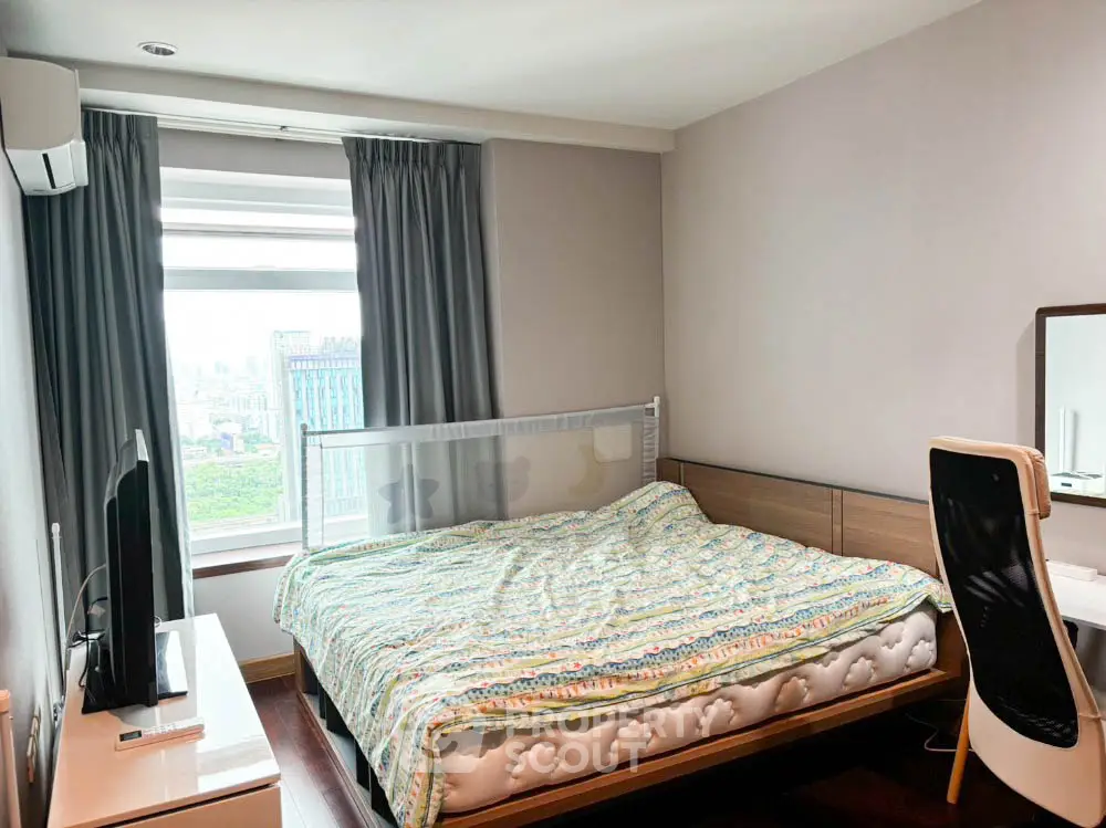 Modern bedroom with city view, featuring a cozy bed and sleek furniture.