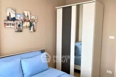 Cozy bedroom with modern wardrobe and stylish wall art, perfect for relaxation.