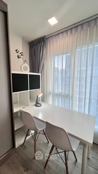 Modern study room with sleek white desk and chairs, large window with sheer curtains, and stylish decor.