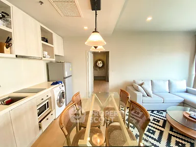 Modern open-layout kitchen and living room with stylish furniture and appliances.