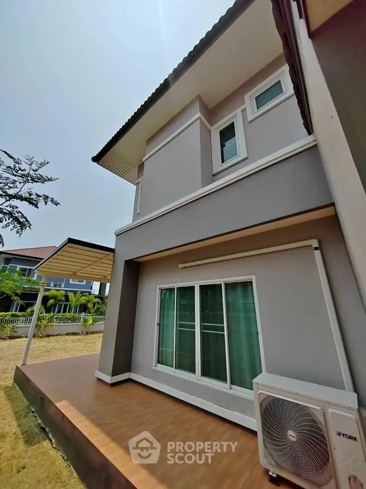 Modern two-story house exterior with patio and air conditioning unit.