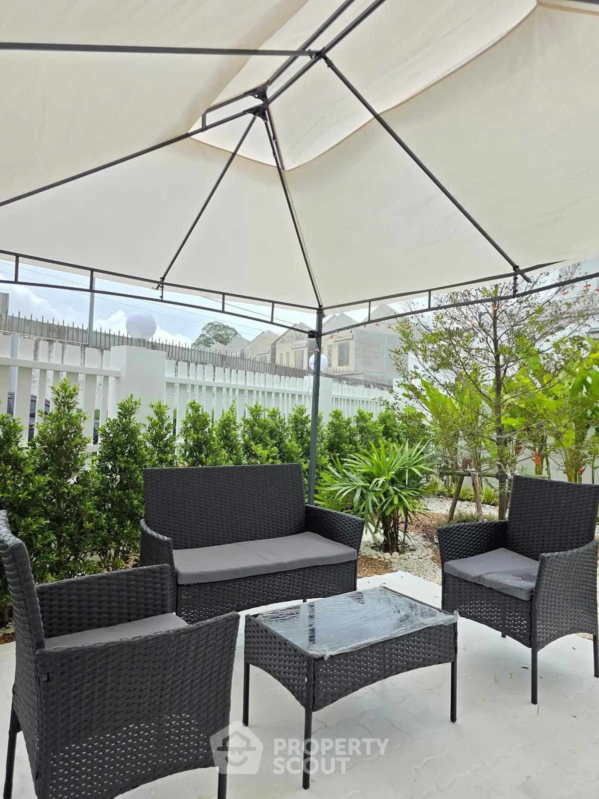 Charming outdoor patio with elegant seating under a stylish canopy, perfect for relaxation and entertaining.