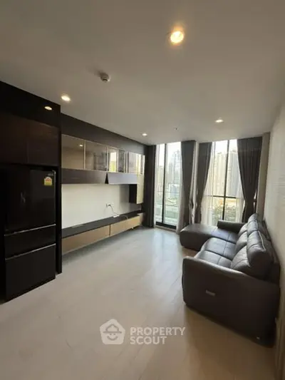 Modern living room with city view, sleek furniture, and large windows.