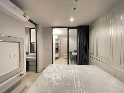 Modern bedroom with elegant decor and ensuite bathroom in a stylish apartment.