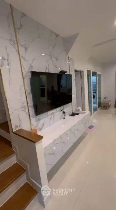 Modern living room with marble accent wall and mounted TV, sleek design