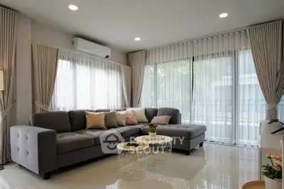Spacious modern living room with large windows and elegant decor