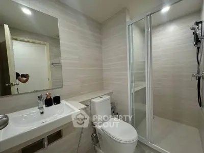 Modern bathroom with sleek design, featuring a glass shower and contemporary fixtures.