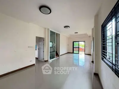 Spacious empty living room with large windows and modern lighting