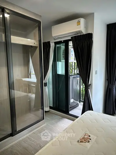 Modern bedroom with balcony access and sleek glass wardrobe design