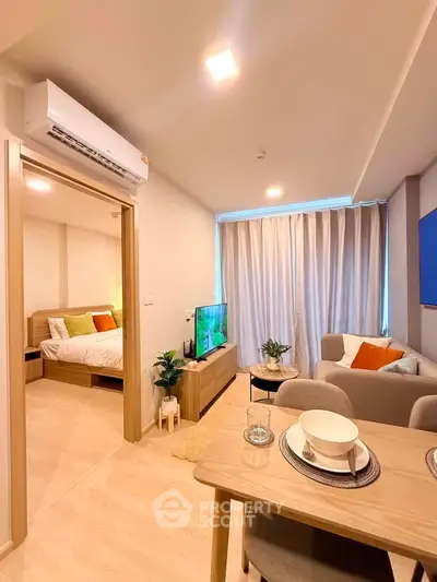 Modern open-plan living room with cozy dining area and bedroom view