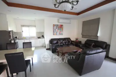 Spacious open-plan living room with modern kitchen and leather sofas