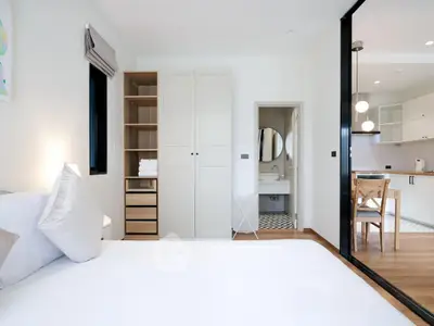 Modern bedroom with ensuite bathroom and open kitchen layout
