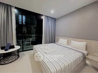 Modern bedroom with stylish decor and balcony access in a luxury apartment.