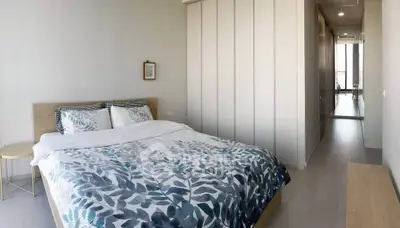 Spacious bedroom with modern decor and ample natural light in a stylish apartment.