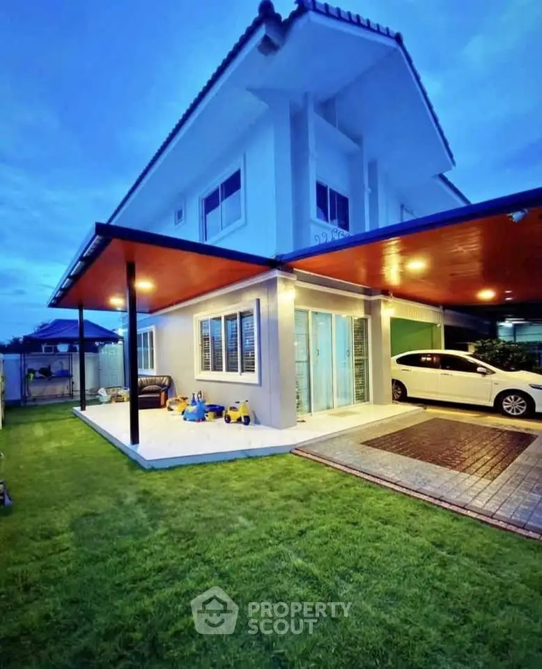 Charming two-story house with carport and lush green lawn, perfect for family living.