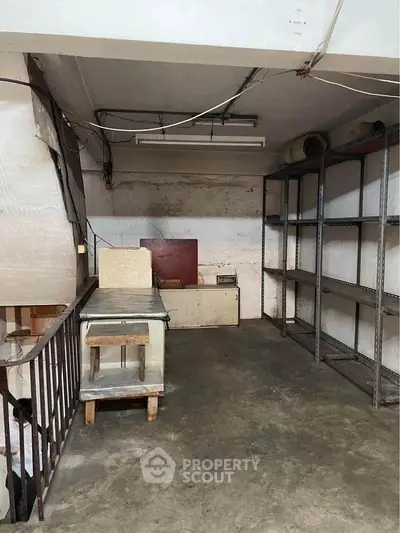 Industrial storage space with concrete floor and metal shelving, ideal for warehouse needs.
