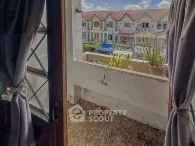 Charming balcony view overlooking a row of colorful townhouses, perfect for enjoying sunny days.