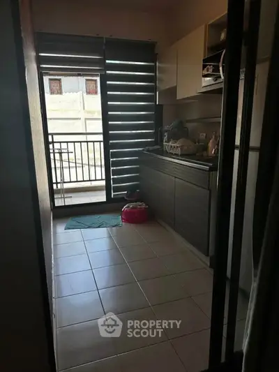 Cozy kitchen with modern cabinets and balcony access, perfect for urban living.