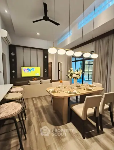 Modern open-plan living and dining area with stylish lighting and elegant decor.